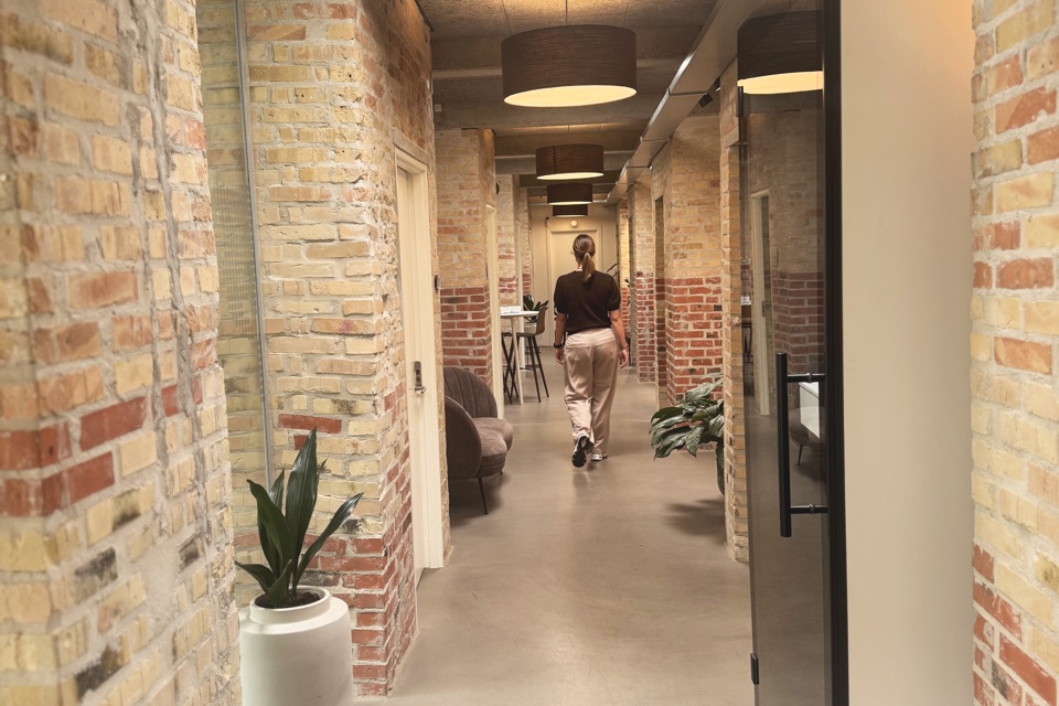 Lys kontorgang med murstensvægge